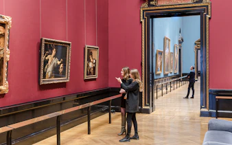 Visitors exploring paintings at Kunsthistorisches Museum, Vienna.