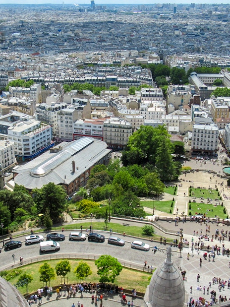 View of Paris from Montmartre Sacré-Cœur Cathedral, overlooking cityscape and gardens.