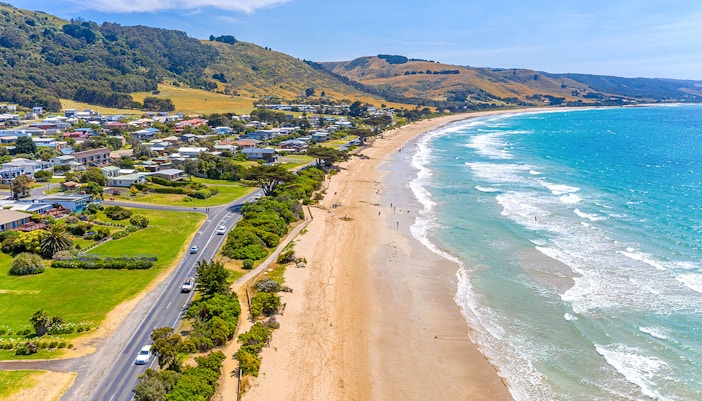 Coastal view of Apollo Bay with lush hills and ocean in Victoria, Australia.