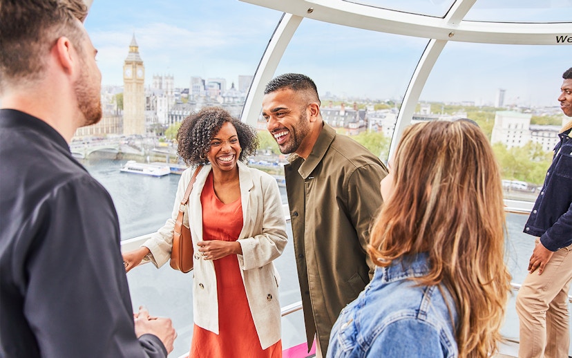 Group enjoying view inside the London Eye with Big Ben in the background.