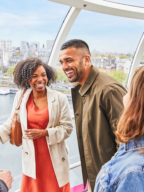 Group enjoying view inside the London Eye with Big Ben in the background.