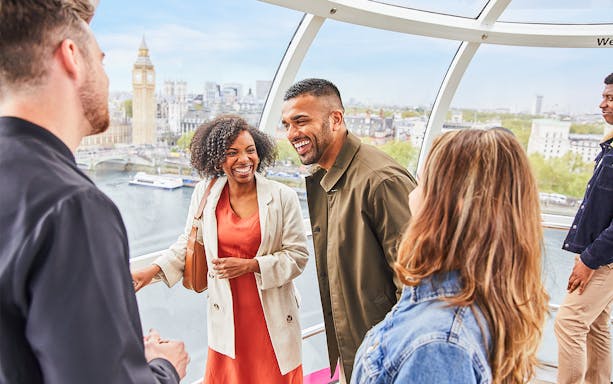Group enjoying view inside the London Eye with Big Ben in the background.