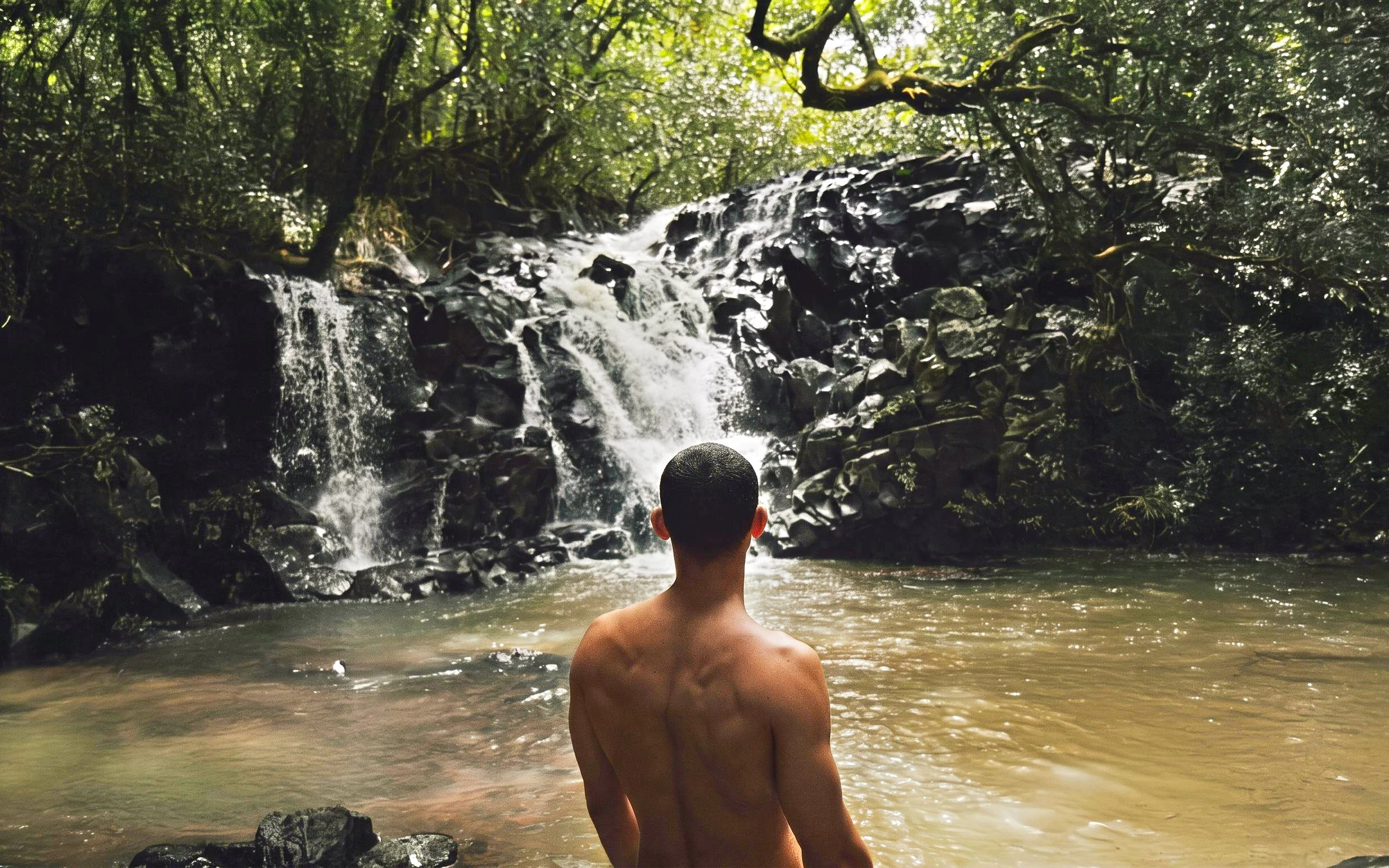 Person standing by a waterfall on the Bel Ombre walking trail.