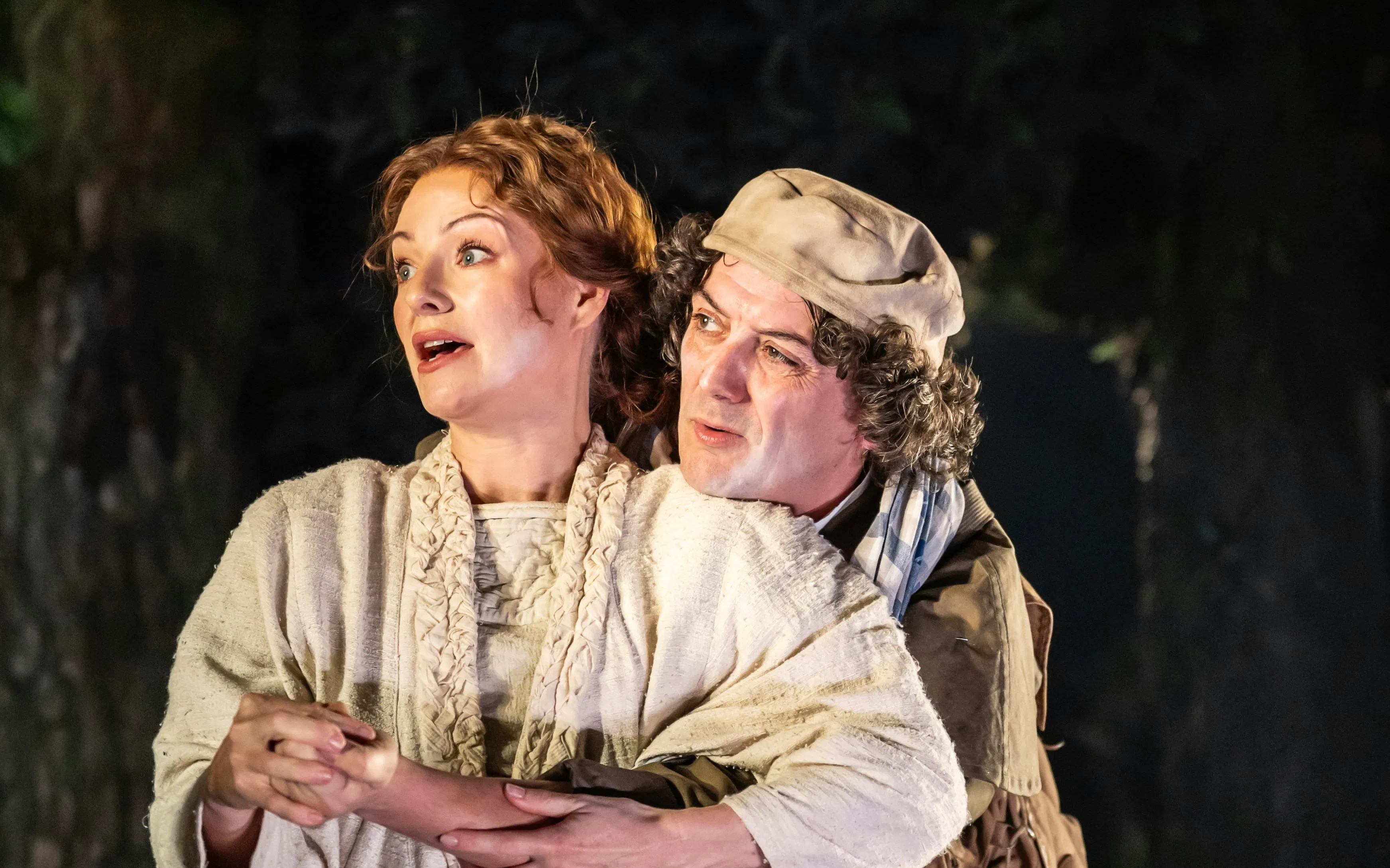 Actors performing a scene from "Into the Woods" in a forest setting.