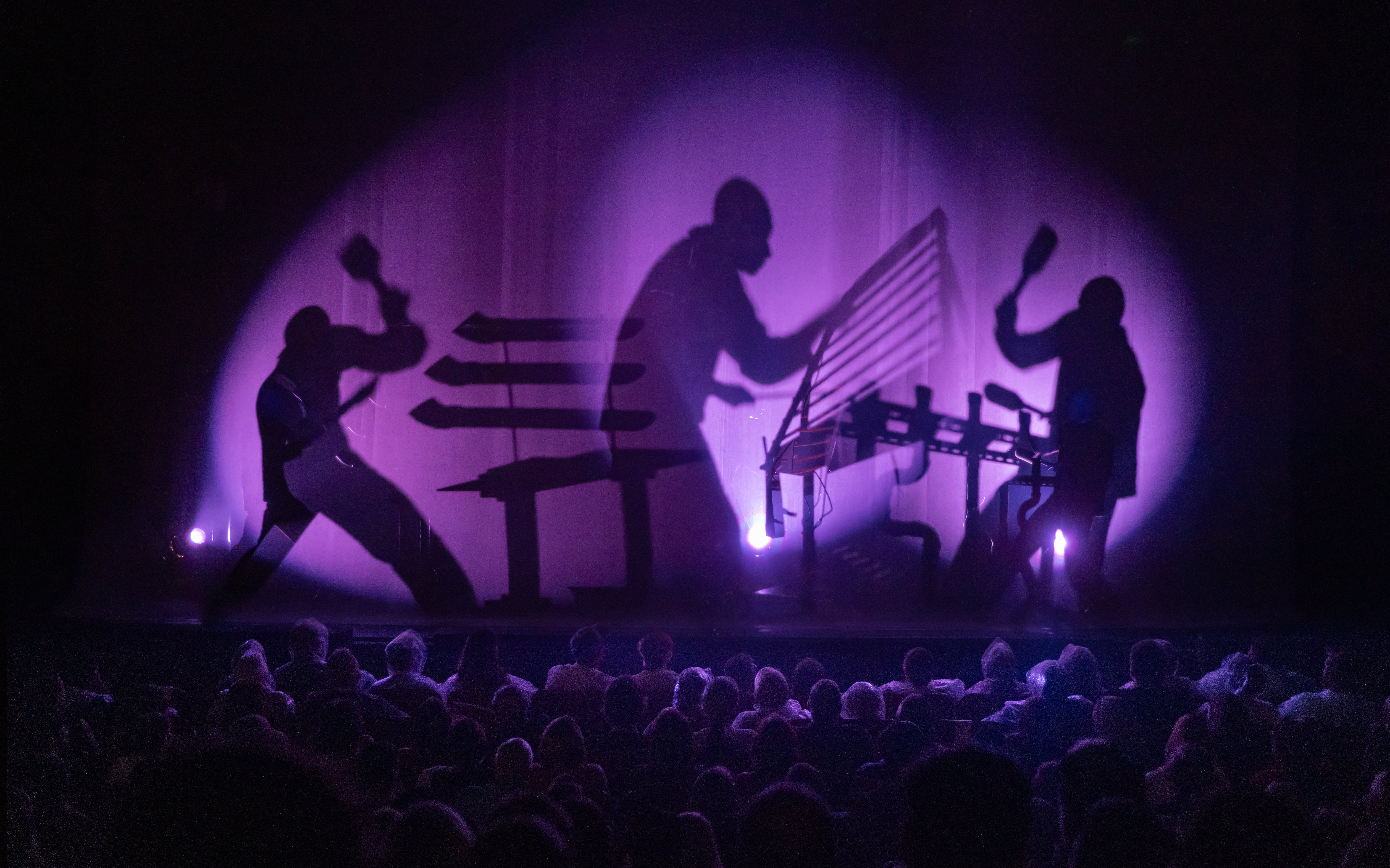 Blue Man Group performing on stage with shadow effects in Orlando.