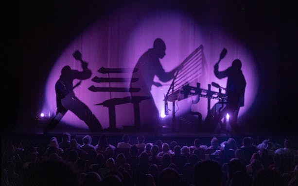 Blue Man Group performing on stage with shadow effects in Orlando.