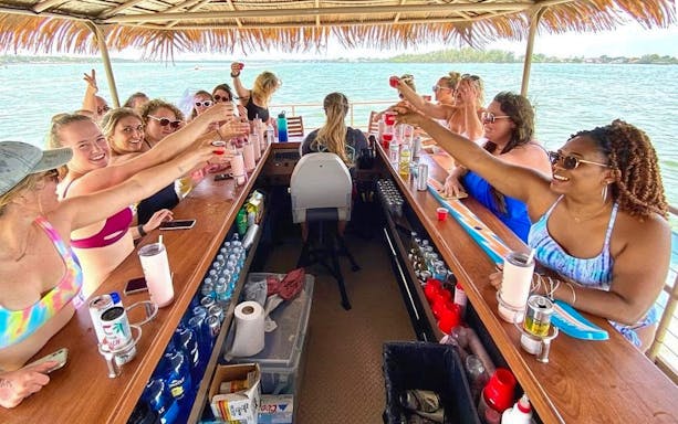 Group enjoying drinks on Prague Tiki Boat, the floating bar on the water.