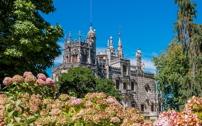 Quinta da Regaleira palace in Lisbon surrounded by lush gardens.