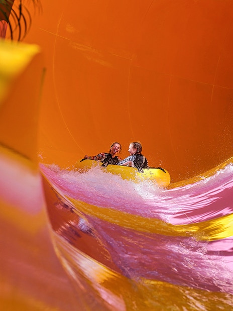 Two girls on a water tube sliding down the Python waterslide at Waterbom Bali.