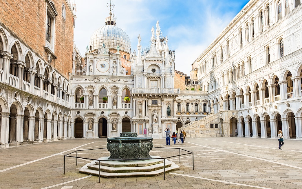 Doge's Palace courtyard with ornate architecture and central fountain in Venice, Italy.