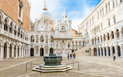 Doge's Palace courtyard with ornate architecture and central fountain in Venice, Italy.