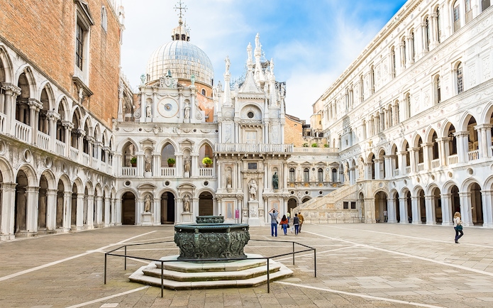 Doge's Palace courtyard with ornate architecture and central fountain in Venice, Italy.