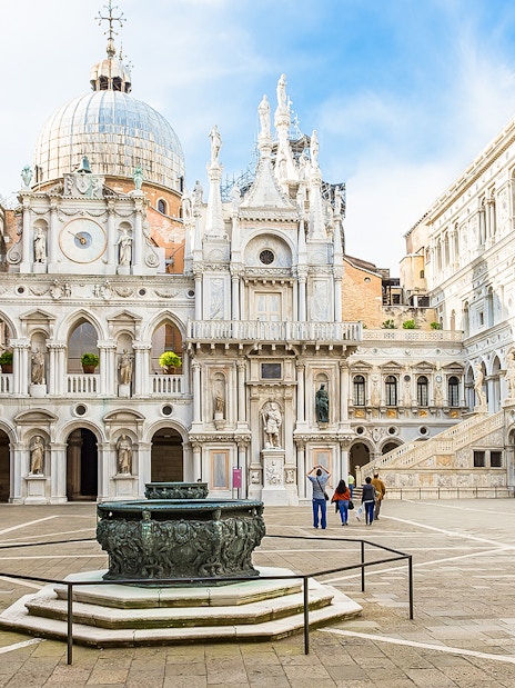 Doge's Palace courtyard with ornate architecture and central fountain in Venice, Italy.