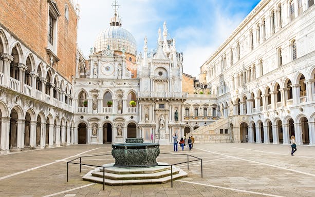 Doge's Palace courtyard with ornate architecture and central fountain in Venice, Italy.