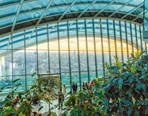 Visitors enjoying the view at Sky Garden, London with cityscape backdrop.