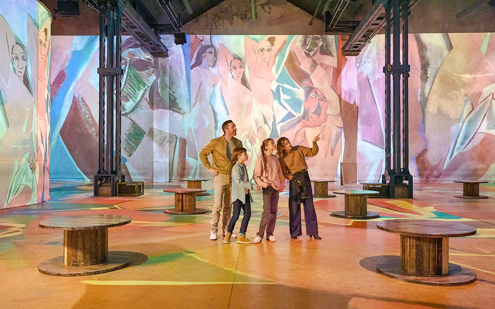 Family exploring digital art projections at Atelier des Lumières, Paris.