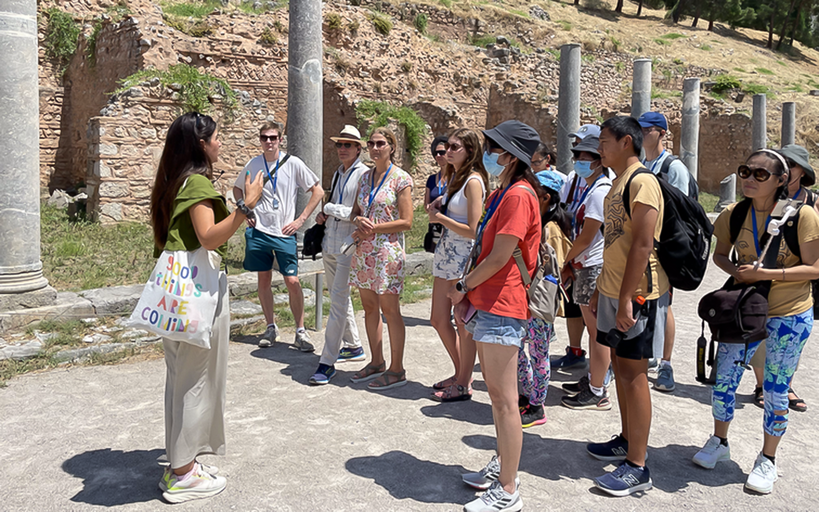 Tour guide explaining ruins to tourists during Day Trip to Delphi and Arachova.