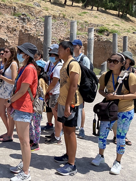 Tour guide explaining ruins to tourists during Day Trip to Delphi and Arachova.