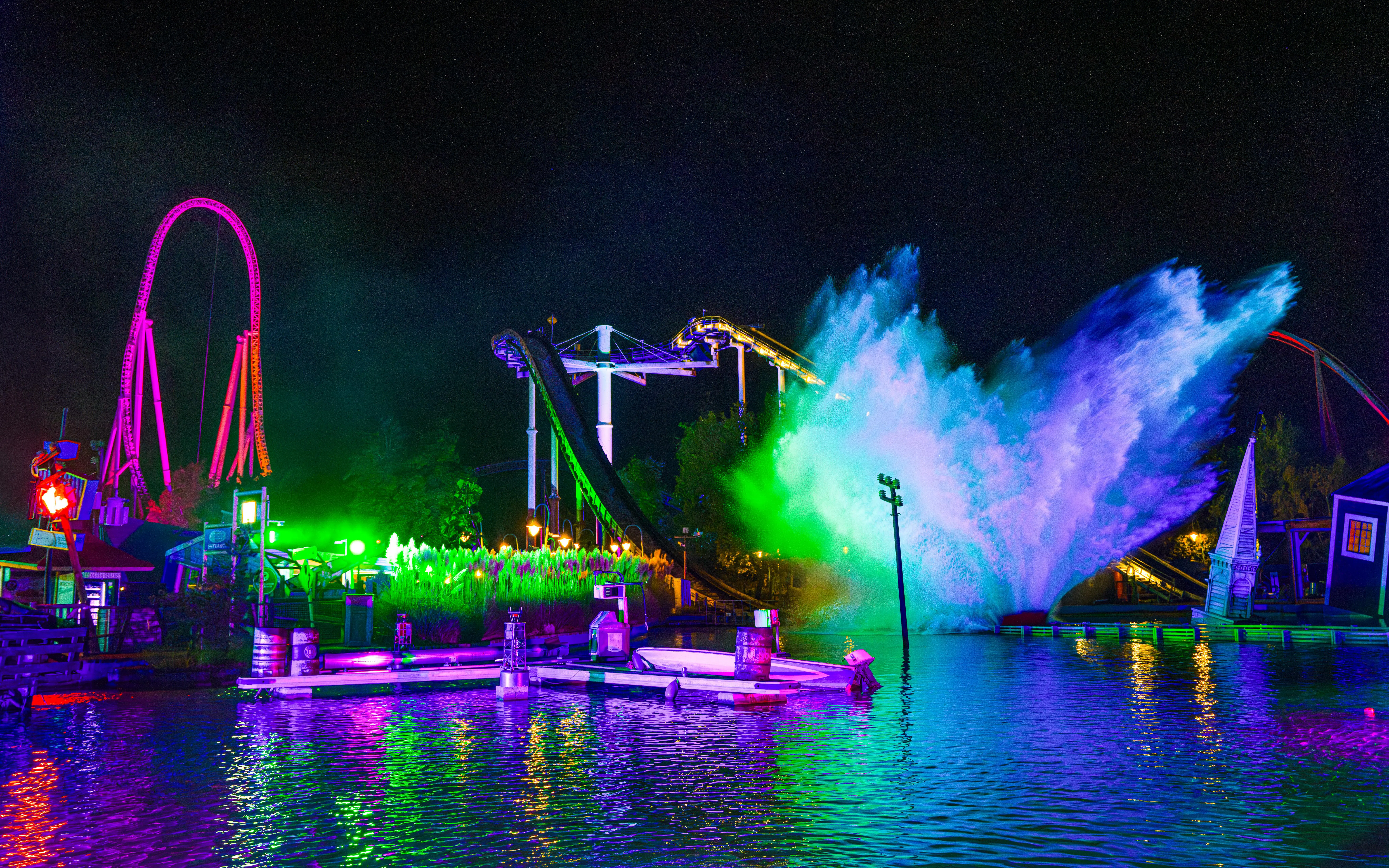 Thorpe Park Fright Nights water ride with colorful lights and splash at night.