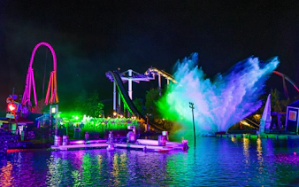 Thorpe Park Fright Nights water ride with colorful lights and splash at night.