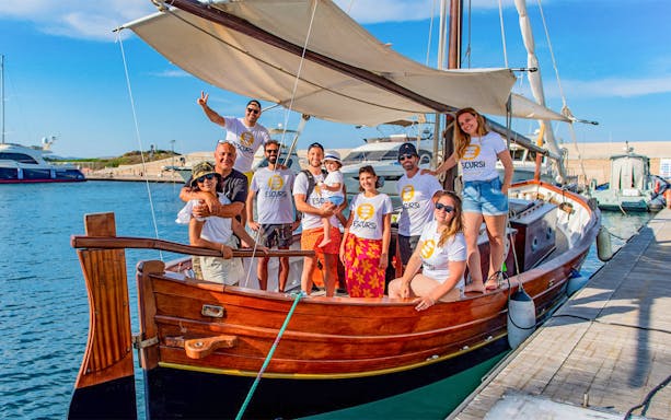 Group on a wooden sailboat at Asinara Island dock, ready for excursion.
