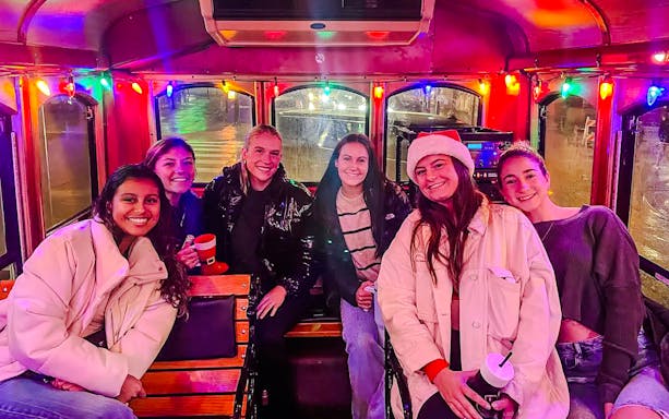 Group enjoying Philadelphia Holiday Lights Tour inside decorated trolley.