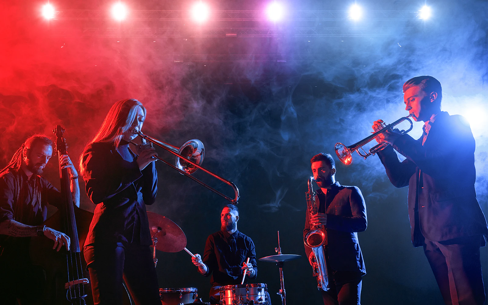 Jazz band performing on stage with colorful lights and smoke effects.