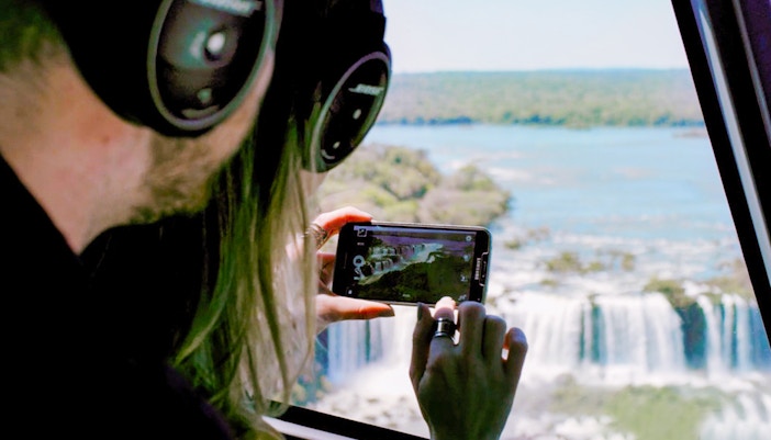 A woman clicking photo of the Iguazu Falls from the helicopter