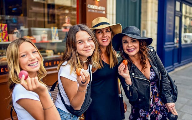Group enjoying macarons on a Paris Saint Germain food tour.