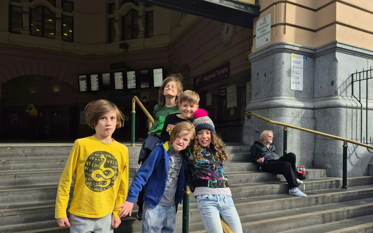 Children on steps outside Flinders Street Station, Melbourne, part of the self-guided city exploration game.