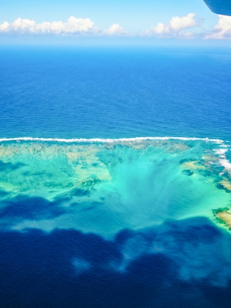 Aerial view of the underwater waterfall illusion near Mauritius on a seaplane tour.