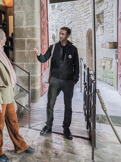 Visitors listening to a guide at Mont Saint-Michel entrance.