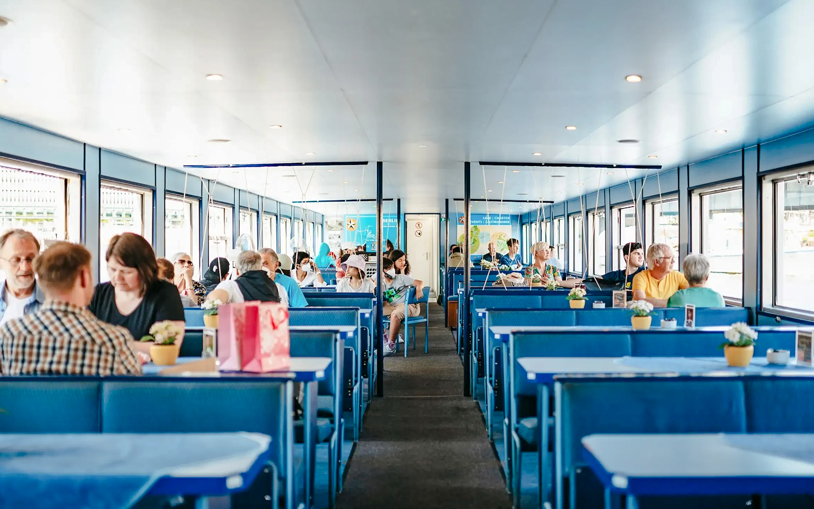 Passengers seated inside a Berlin Spree River sightseeing cruise boat.