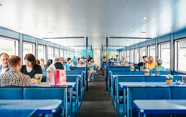 Passengers seated inside a Berlin Spree River sightseeing cruise boat.