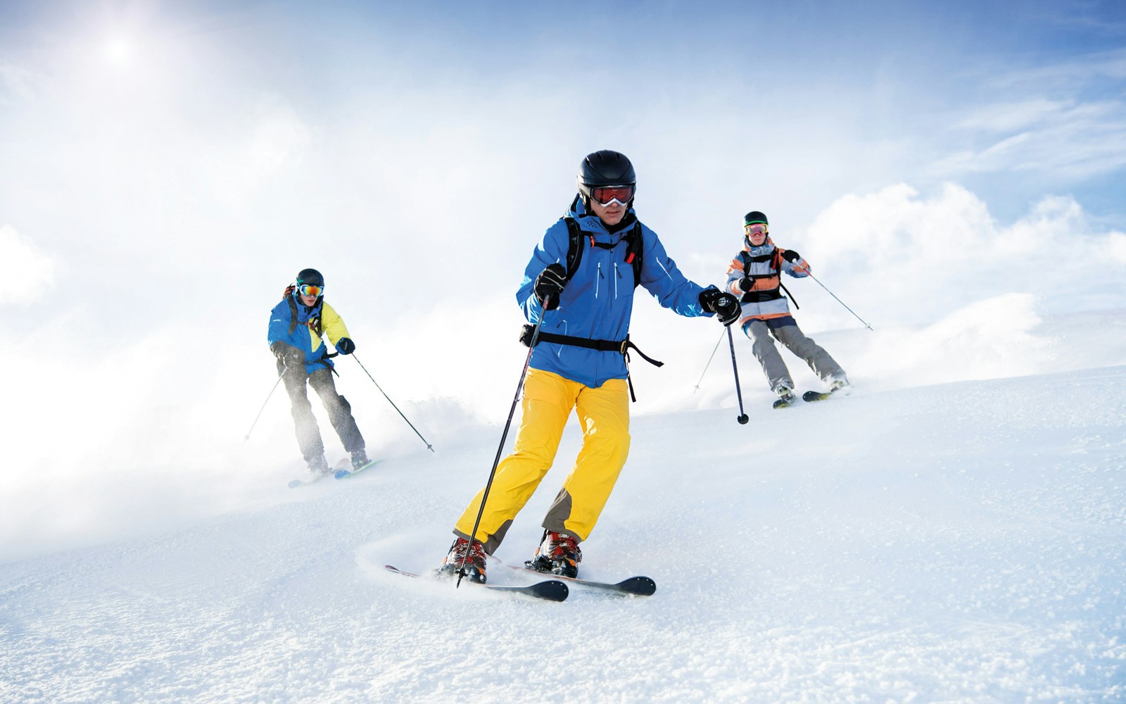 Skiers descending a snowy slope under a clear sky, showcasing global skiing adventure.