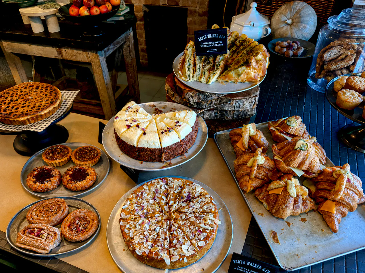 Assorted pastries and cakes at a Sydney café, featuring croissants and almond-topped desserts.