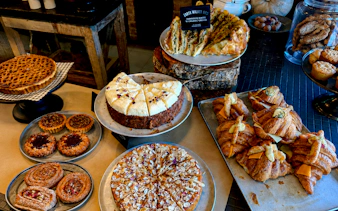 Assorted pastries and cakes at a Sydney café, featuring croissants and almond-topped desserts.
