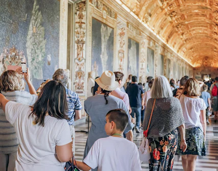 Visitors exploring the ornate halls of the Vatican Museums on a small group tour.