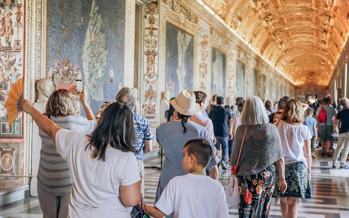 Visitors exploring the ornate halls of the Vatican Museums on a small group tour.