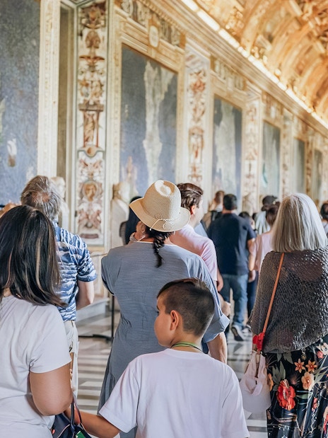 Visitors exploring the ornate halls of the Vatican Museums on a small group tour.