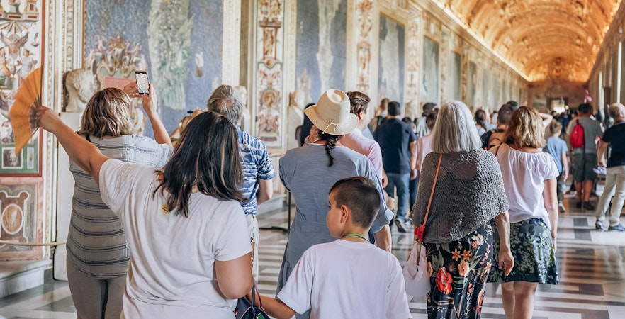 Visitors exploring the ornate halls of the Vatican Museums on a small group tour.