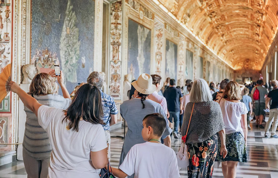 Visitors exploring the ornate halls of the Vatican Museums on a small group tour.