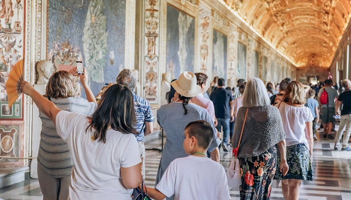 Visitors exploring the ornate halls of the Vatican Museums on a small group tour.