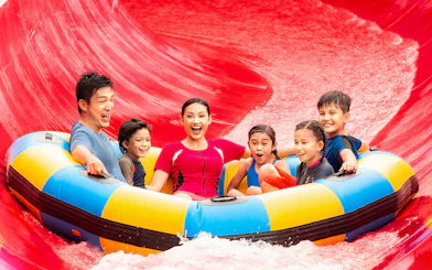 Family on a raft enjoying a water slide at LEGOLAND Malaysia Water Park.