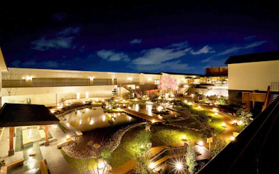 Solaniwa Onsen garden at night with illuminated pathways and pond in Osaka, Japan.