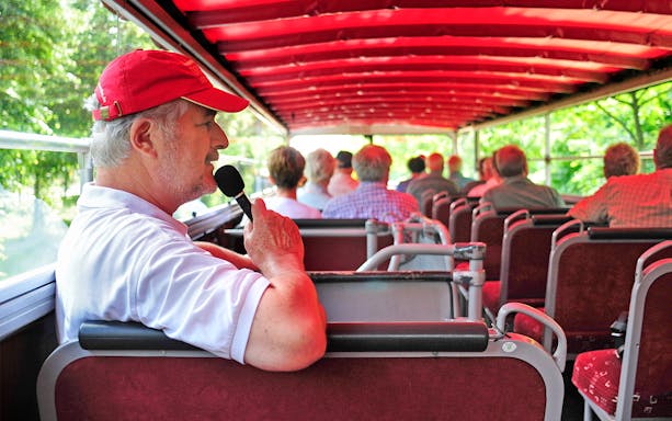Tour guide giving live commentary on a bus tour in Dresden.