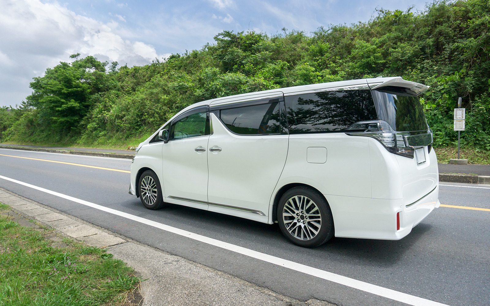 White tour van on a scenic road for Chambord and Chenonceau Tour.