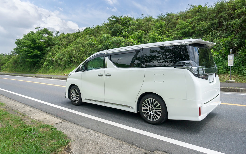 White tour van on a scenic road for Chambord and Chenonceau Tour.