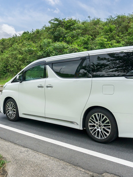 White tour van on a scenic road for Chambord and Chenonceau Tour.