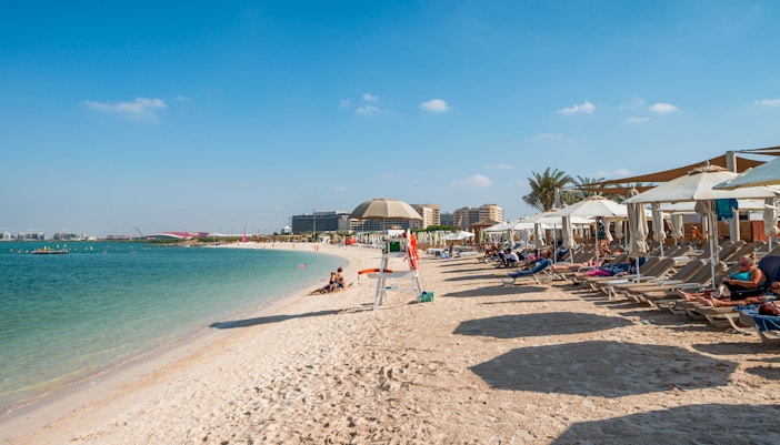 Yas Beach shoreline with sun loungers and umbrellas on Yas Island, Abu Dhabi.